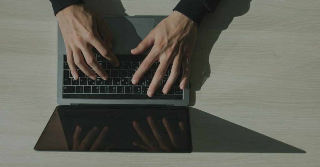 Business professional reviewing email security alerts on a laptop in a Southwest Florida office