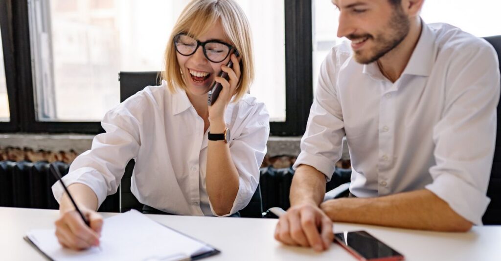An office worker on a phone call at a desk, representing a help desk impersonation phone scam